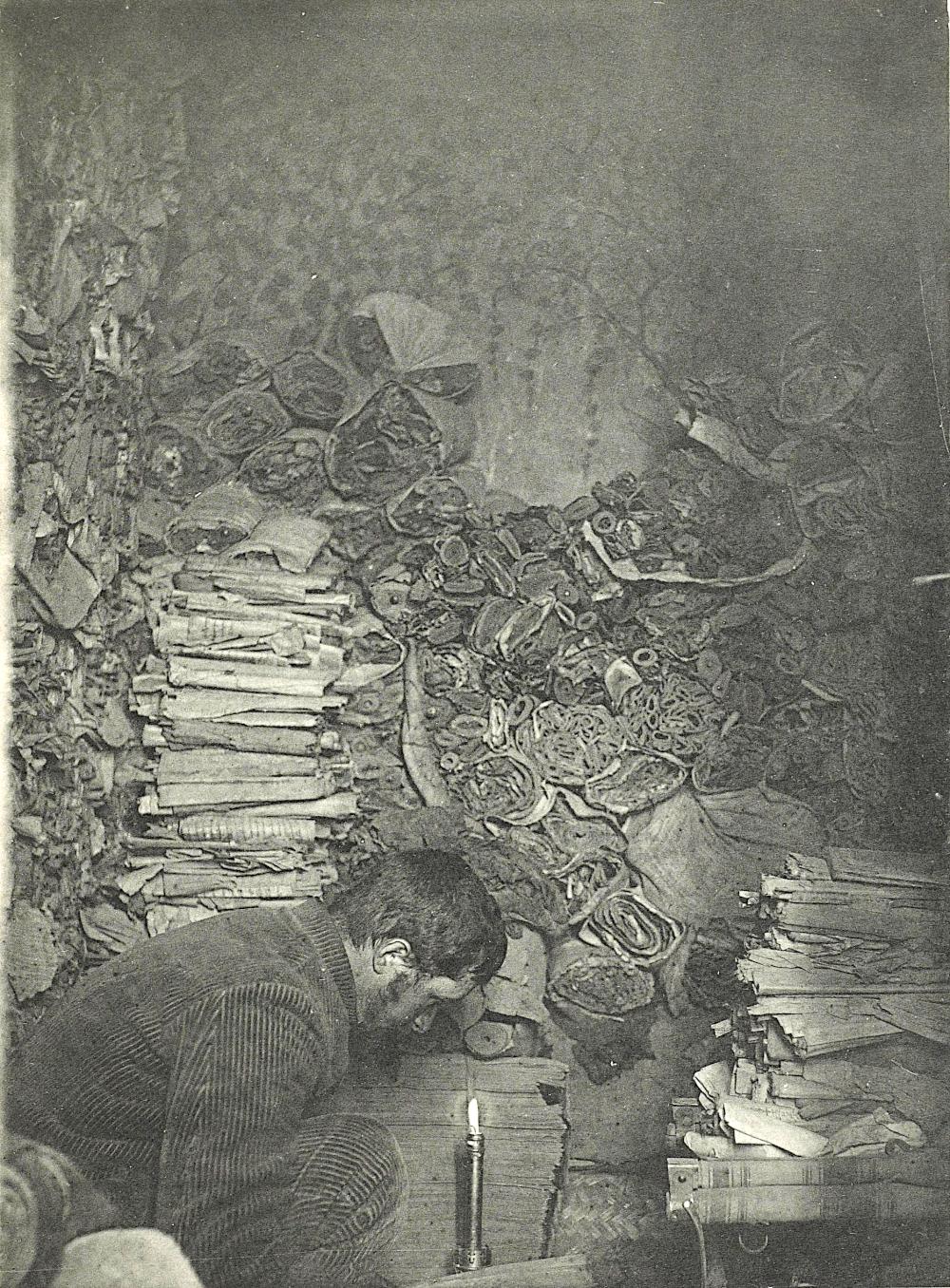Paul Pelliot sorting manuscripts inside cave 17 in 1907 at Dunhuang