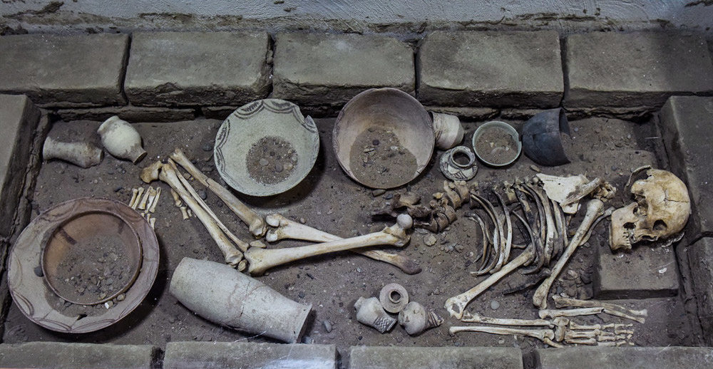 Shar-i-Shokta excavated tomb with skeleton and eating-drinking wares (Iran)